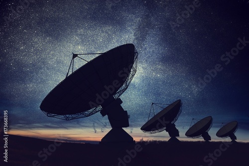 Silhouettes of satellite dishes or radio antennas against night sky. Space observatory.