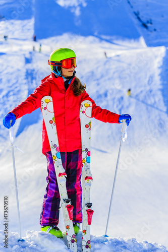 Girl standing with arms spreading wide open on the fresh powder snow at sunny day in mountains. Swiss Alps.