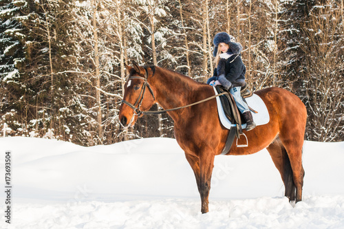 Small girl and horse in a winter