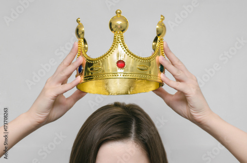 Woman girl holding above a head the golden crown. Leadership, success , queen.