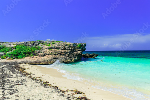amazing inviting view on a cliff sitting in tranquil turquoise ocean and beach against blue sky magic background at Cayo Coco Cuban island on sunny summer day