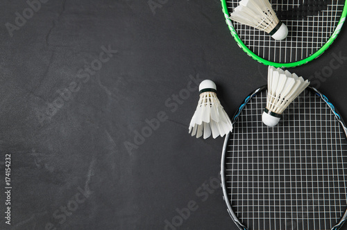 Shuttlecocks and badminton racket on black background.