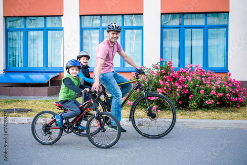 Family cycling, father with happy kid riding bike outdoors