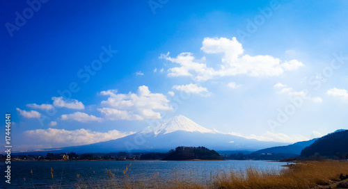 Mount Fuji with white clouds and blue skies.Lake foreground and Brown meadow, Japan