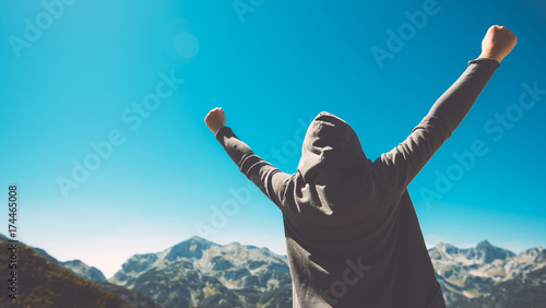 Winning and success. Victorious female person on mountain top.
