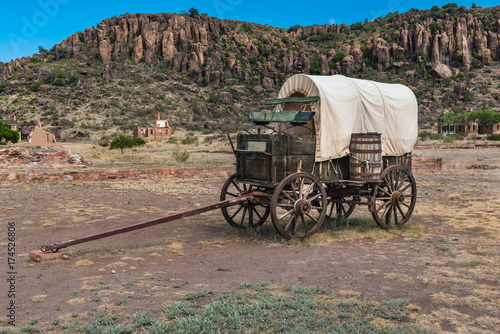 Side view of canvas covered wagon with green buck board