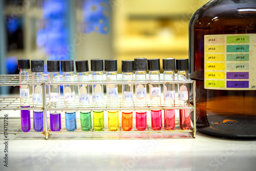 Preparation of standard pH solution, Matching the color of the bottle with the Universal Chemical Indicator in chemistry laboratory. Close up image.