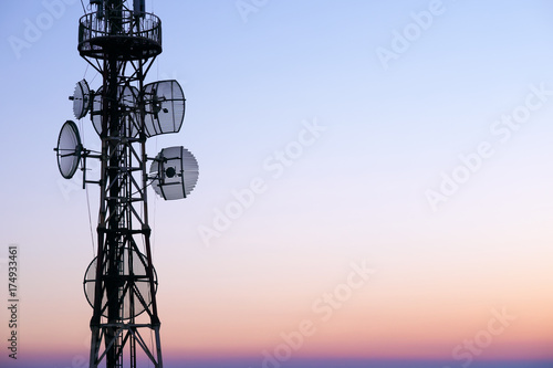 Telecommunication tower Antenna at sunset sky.