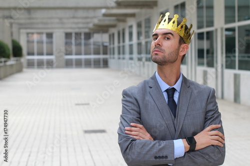 Arrogant businessman with a crown in office space 