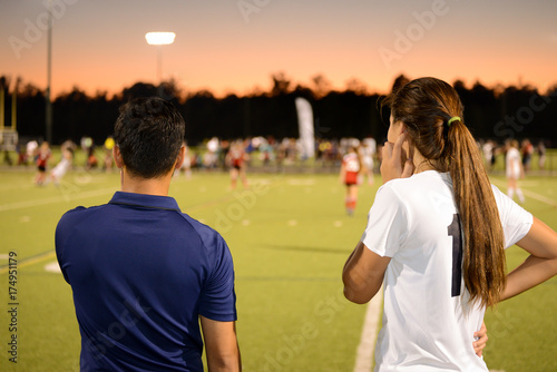 Coach and player on sidelines