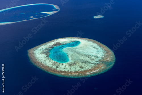 Colorful aerial photo of small island in Maldives atolls and deep blue sea