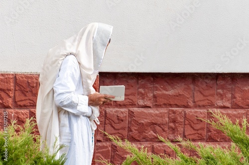 Orthodox hassidic Jew pray in a holiday robe and tallith.