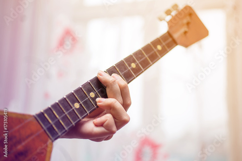 the fingers on the strings of the balalaika closeup