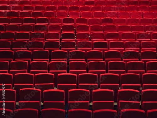 Rangées de fauteuils rouges dans une salle de spectacle