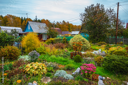 A suburban area with a flower garden in the fall