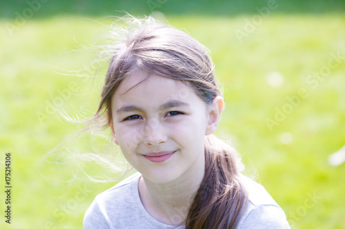Portrait of girl on a green meadow