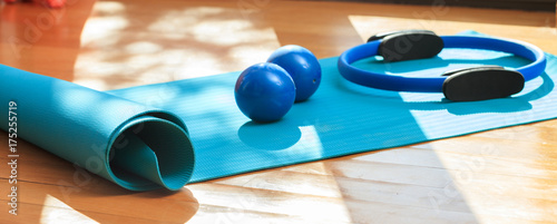 Yoga mat and exercise weights on wooden floor