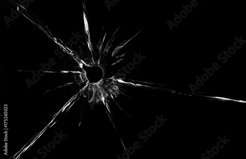 bullet hole in glass close up on black background