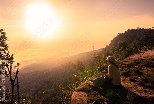 Happy woman sitting on a cliff side