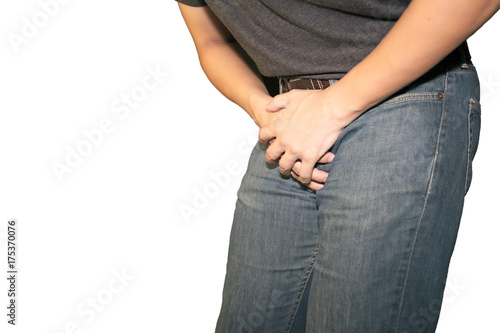 Boy is suffering and holding his genitals on white background with copy space