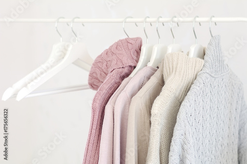 Warm pastel sweaters on hangers