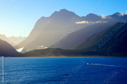 Boat sailing Tasman Sea to Milford Sound in early morning mist