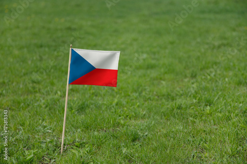 the Czech Republic flag, Czech flag on a green grass lawn field background. National flag of Czech Republic waving outdoor