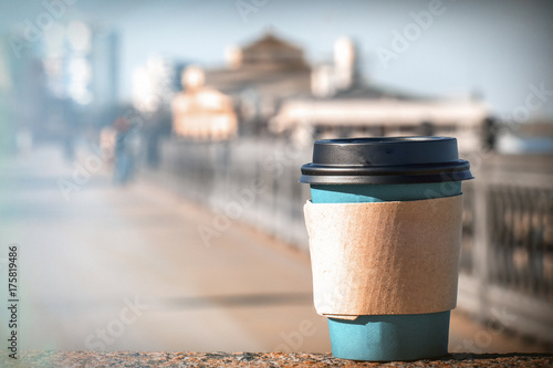 A disposable cup of coffee on a city background