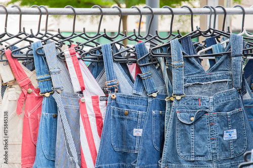 Pair of denim dungarees on hangers.