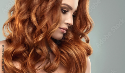Piękna modelka z długimi rudymi kręconymi włosami. Czerwona głowa. Produkty do pielęgnacji i urody