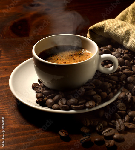 coffee cup with spoon, near coffee grains 