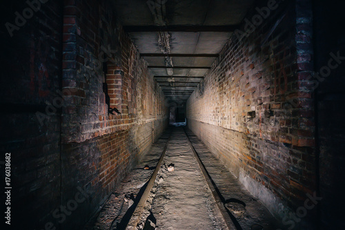 Dark scary corridor in abandoned industrial ruined brick factory, creepy interior