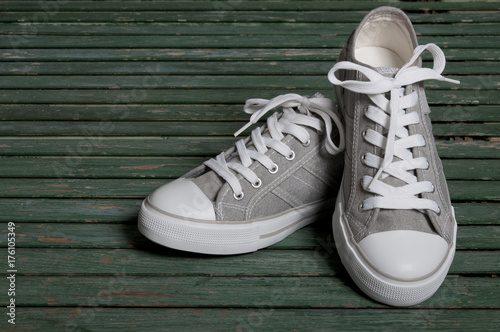 gray sneakers on a wooden green background