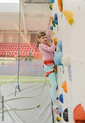 Active caucasian girl on the climbing wall