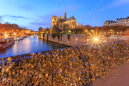 PARIS, FRANCE : Notre dame in Paris (Our Lady of Paris) at twilight. It is a medieval Catholic cathedral, Love lockers at Pon des arts bridge across Seine river