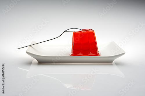 gelatina roja en un plato y cuchara lista para comer