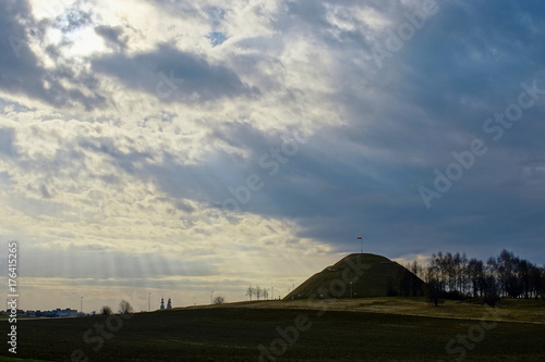 Promienie słoneczne padają przez chmury na kopiec, górę. Zdjęcie krajobrazowe HDR.