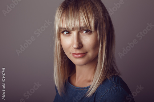 Closeup portrait of beautiful young middle age blonde Caucasian woman looking in camera. Girl female with long blonde hair bob studio beauty shot.