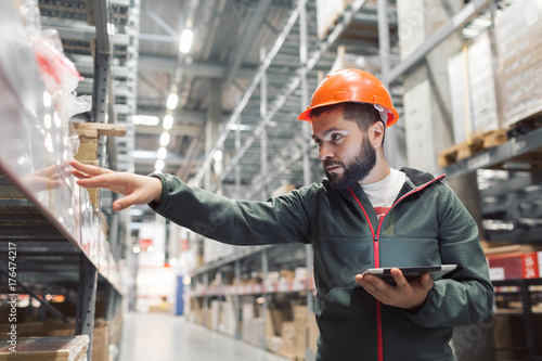 Warehouse manager checking his inventory in a large warehouse