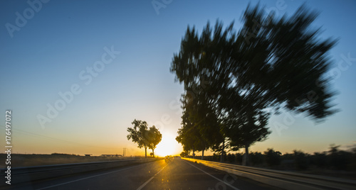 Car driving on freeway at sunset with motion blur