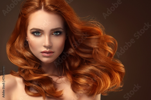 Piękna modelka z długimi rudymi kręconymi włosami. Czerwona głowa. Produkty do pielęgnacji i urody