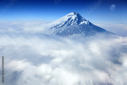 Szczyt górski pokryty śniegiem w chmurach.