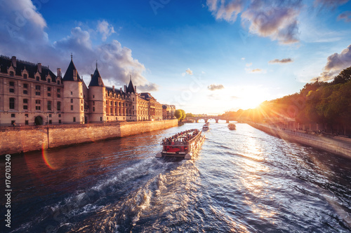 Dramatic sunset over river Seine in Paris, France, with Conciergerie and Pont Neuf. Colourful travel background. Romantic cityscape.