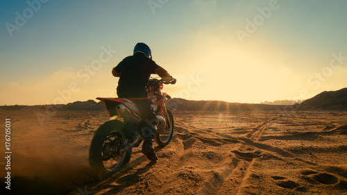 Shot of the Professional Motocross Driver Riding on His FMX Motorcycle on the Extreme Off-Road Terrain Track.