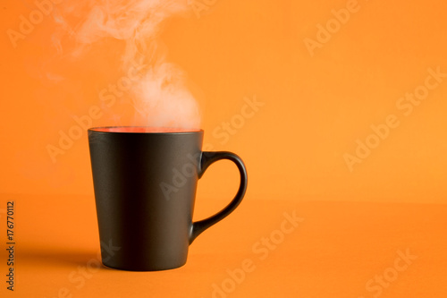 Coffee cup with steam on orange
