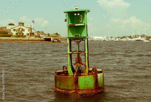 Ocean buoy. Green sea buoy. Centered image. Ocean objects. Weather buoy. Abstract ocean object.Blue sky background.