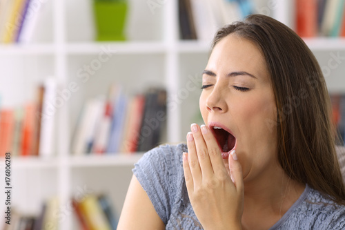 Tired lady yawning at home