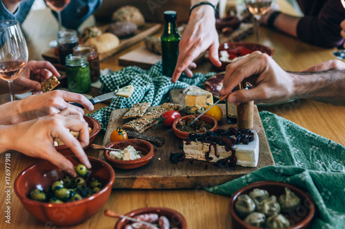 hands picking food on a party table