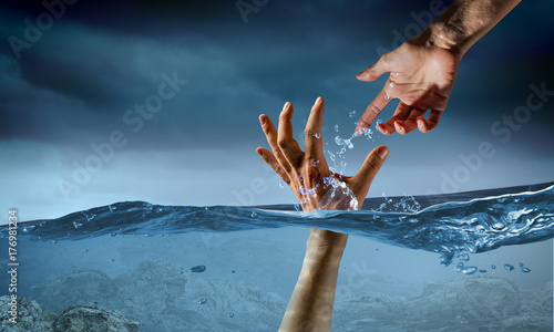 Hand of person drowning in water