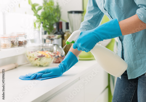 Woman cleaning with a spray detergent